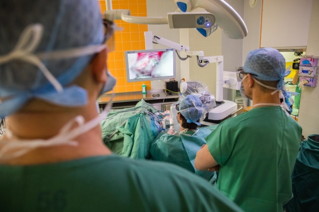„Zvláště pro operace v oblasti ORL je užitečná automatická fixace operačního pole,“ říká zástupce přednosty pro vědu a výzkum Jan Bouček (na fotografii za prof. Plzákem).